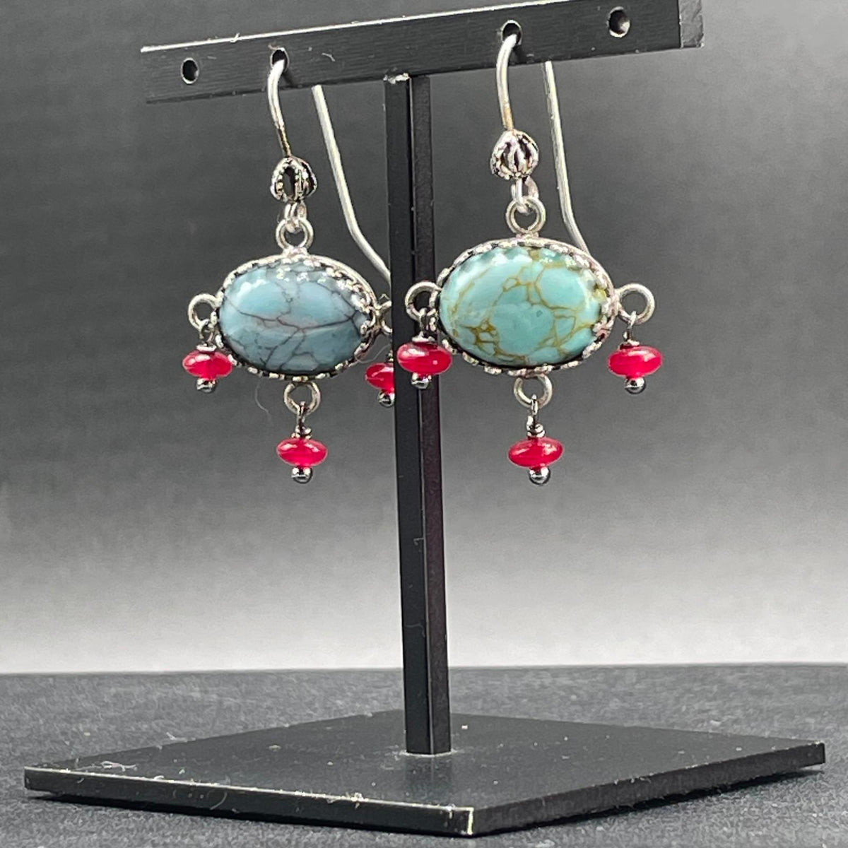 Orecchini BonBon argento 925, montatura decorativa e pietre ovali azzurre, vista obliqua