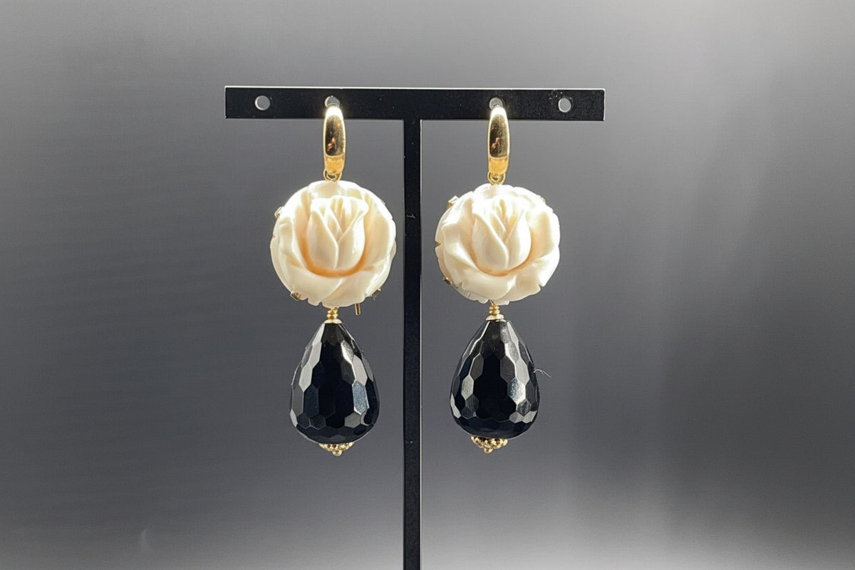 Orecchini in oro 18 kt con avorio fossile di mammut scolpito e gocce sfaccettate di onice nero.