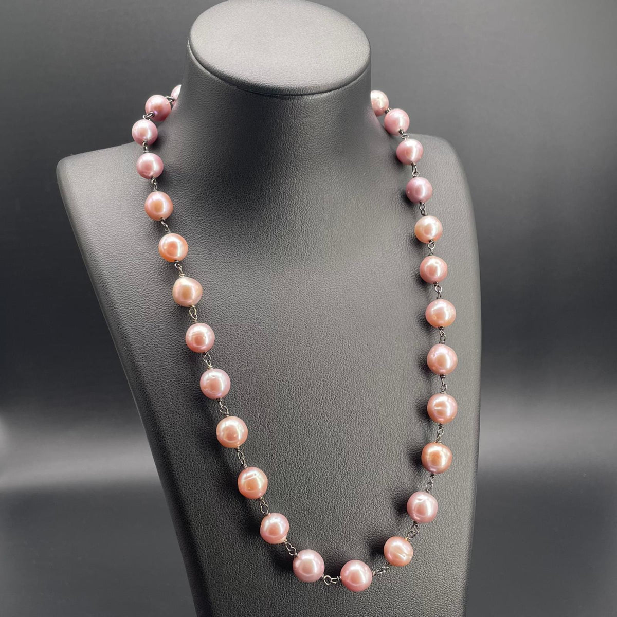 Collana artigianale a rosario con perle coltivate d’acqua dolce color malva e dettagli in argento brunito.