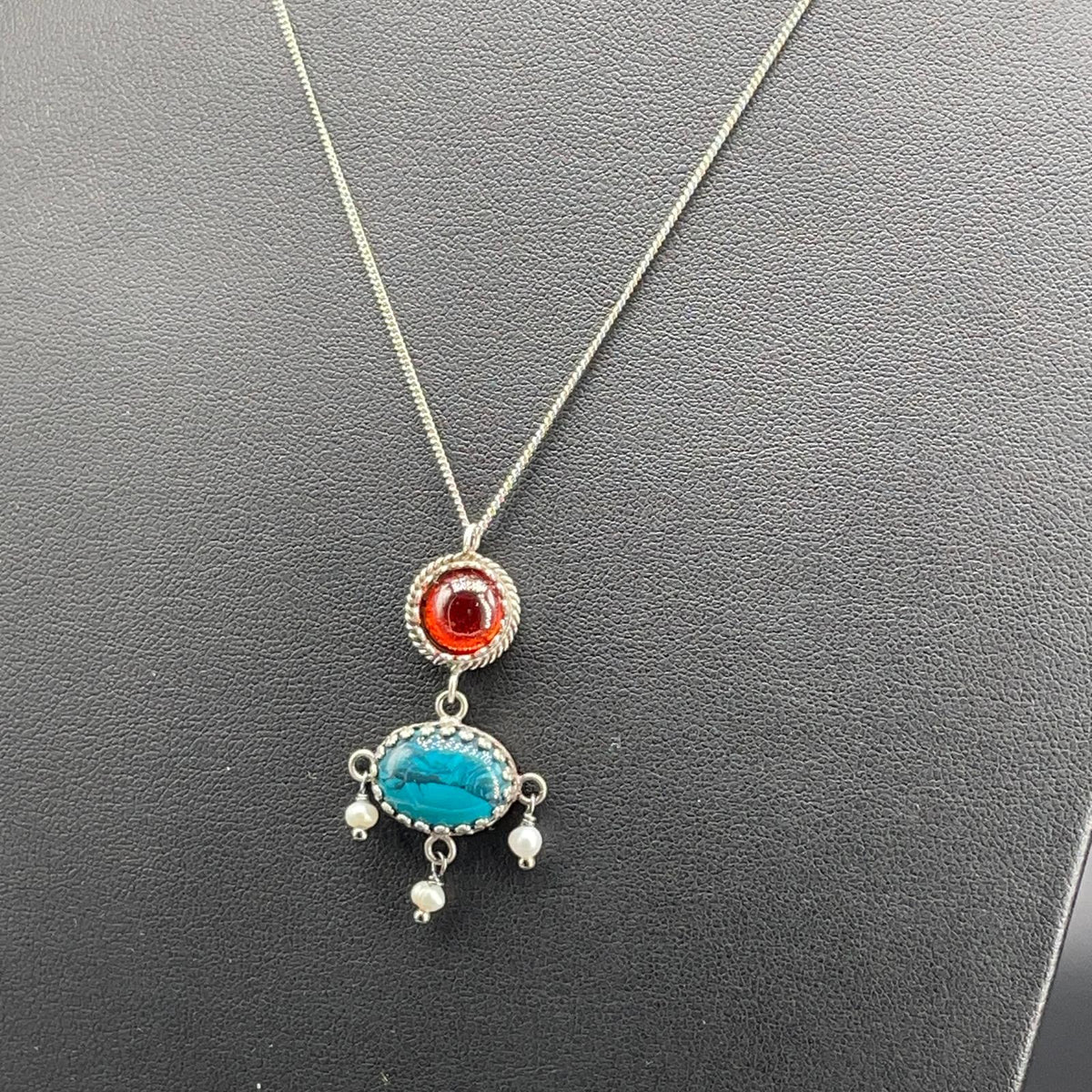 Dettaglio del pendente BonBon in argento 925 con pietre dure rosse e turchesi e tre perle coltivate