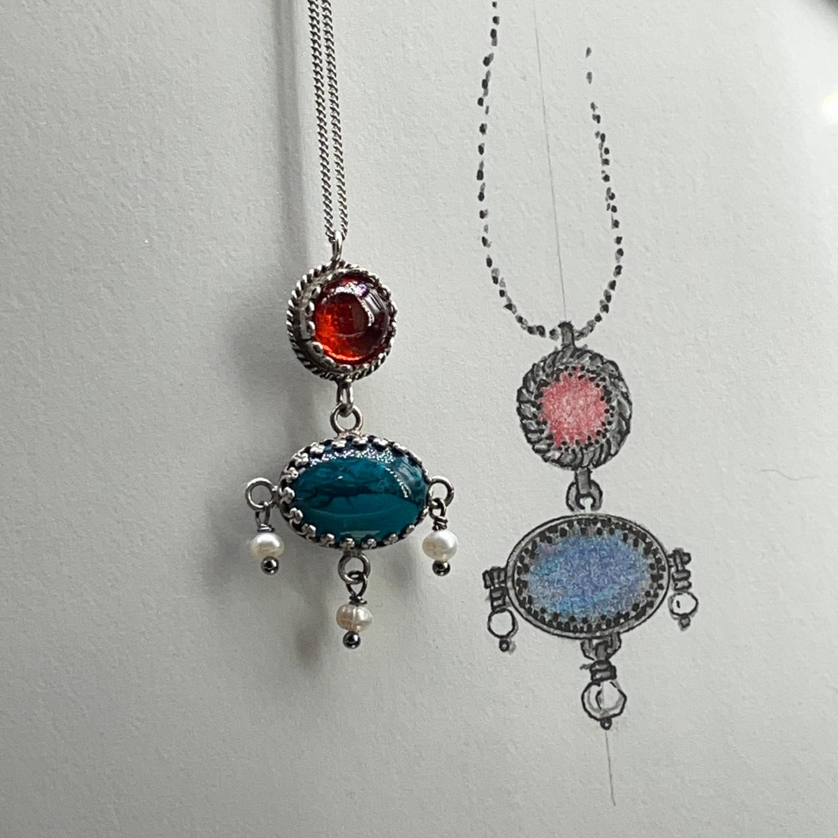 Collana BonBon in argento 925 accanto al disegno preparatorio del pendente