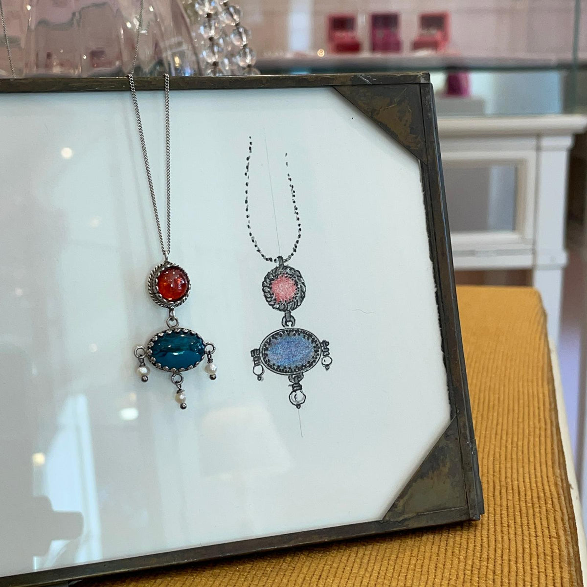 Collana BonBon e disegno del pendente esposti nella gioielleria Lecasematte