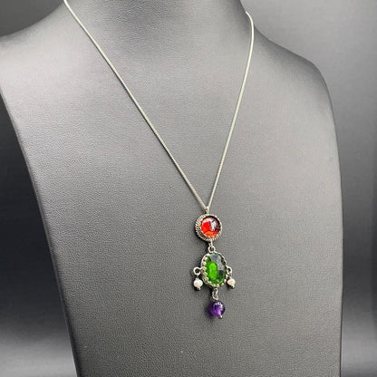 Collana BonBon in argento 925 con pietra verde ovale, elementi rossi e viola e perle coltivate su busto nero