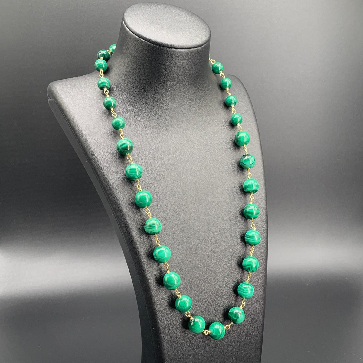 Collana in malachite verde con sfere graduate su busto nero