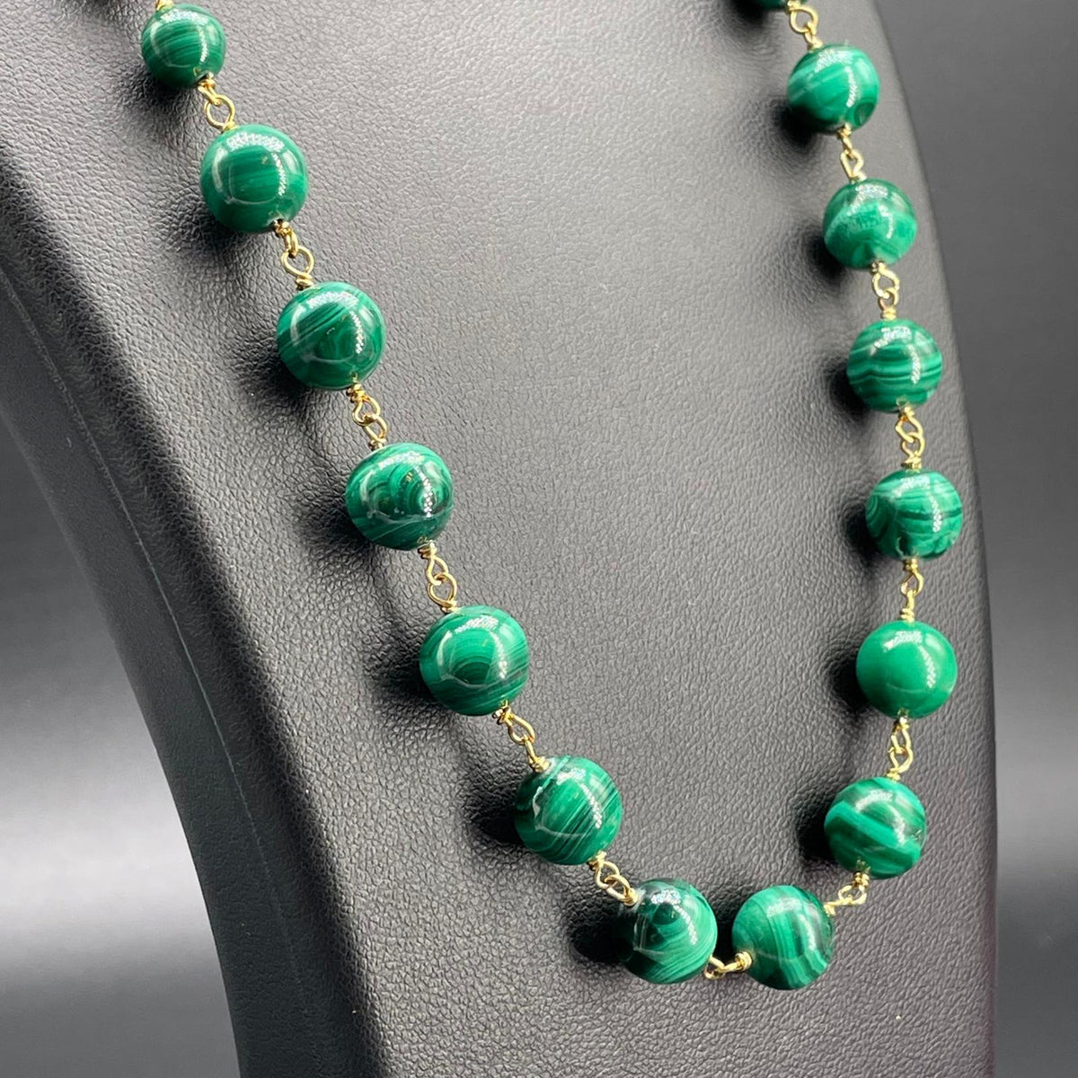 Dettaglio delle sfere di malachite venata e raccordi dorati