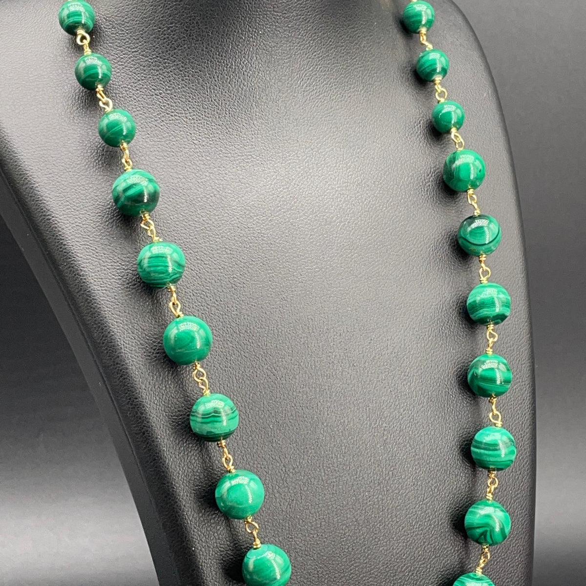 Dettaglio delle sfere di malachite verde venata e raccordi dorati