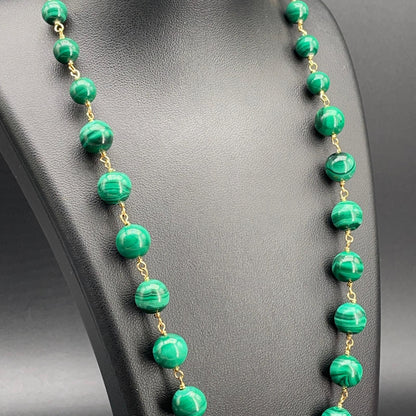 Dettaglio delle sfere di malachite verde venata e raccordi dorati