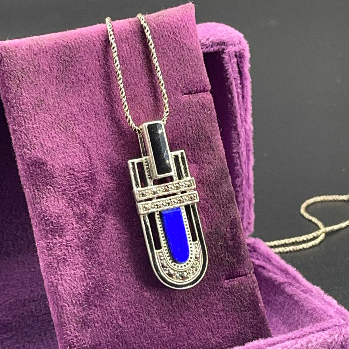 Vista ravvicinata della collana in argento 925 con lapislazzuli blu, onice e marcassiti su velluto viola