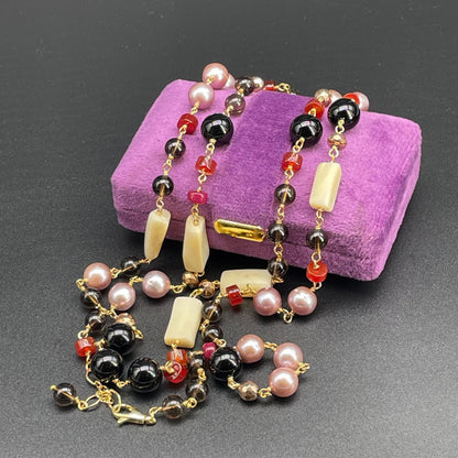 Collana artigianale lunga con pietre multicolori, fotografata distesa