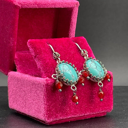 Dettaglio degli orecchini BonBon in argento 925 con pietre venate e pendenti rossi