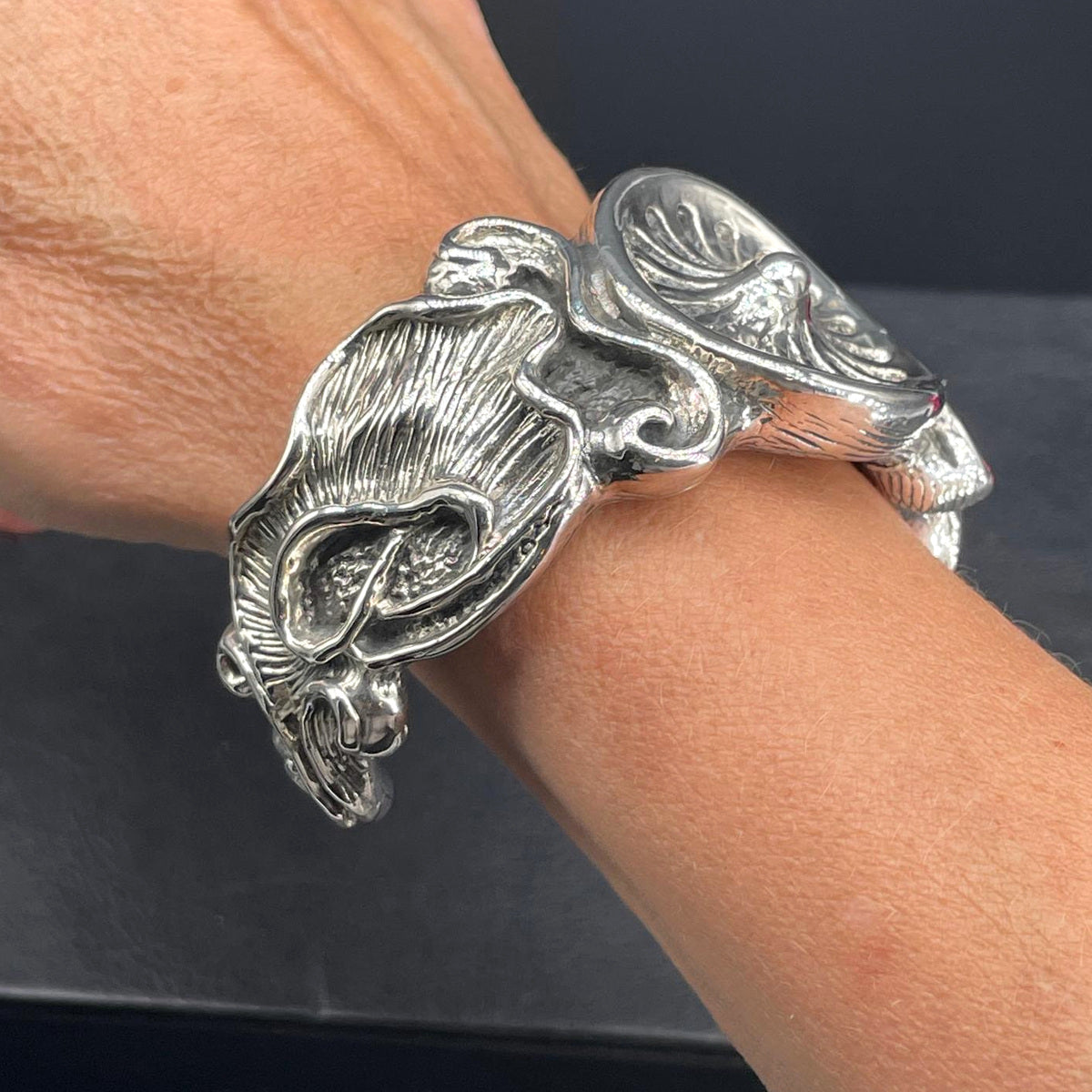 Vista laterale del bracciale in argento elettroformato indossato, dettagli a rilievo e apertura