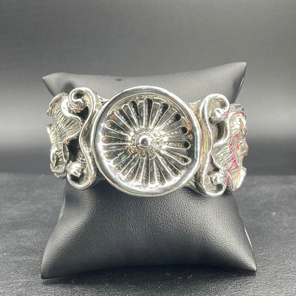Bracciale rigido aperto in argento elettroformato con medaglione a rilievo raggiato e decori floreali, vista frontale