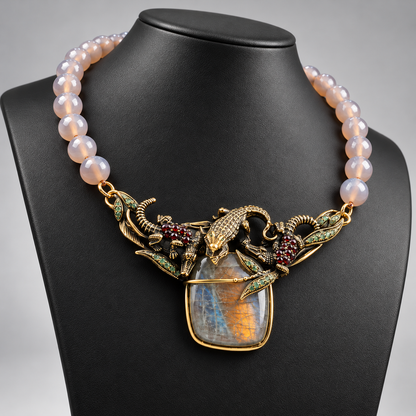 Collana in agata grigia con elemento figurativo in ottone dorato e labradorite, vista angolata