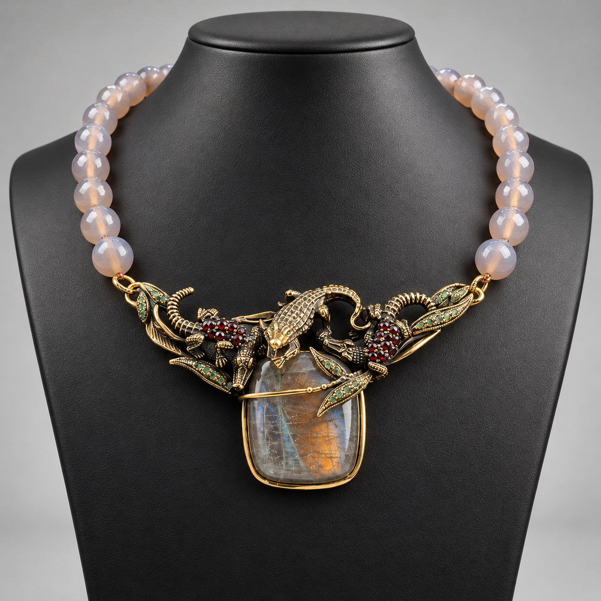 Collana in agata grigia e labradorite, elemento centrale dorato con coccodrilli, smeraldi e granato su busto nero