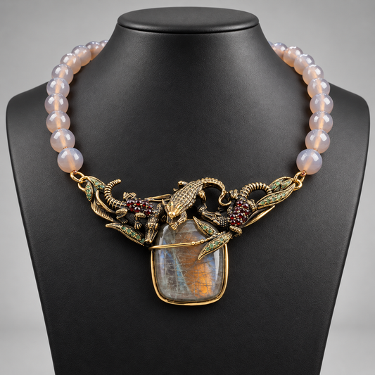 Collana in agata grigia e labradorite, elemento centrale dorato con coccodrilli, smeraldi e granato su busto nero