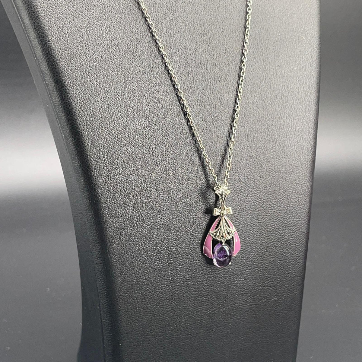 Dettaglio del pendente a goccia con ametista viola cabochon e smalti rosa