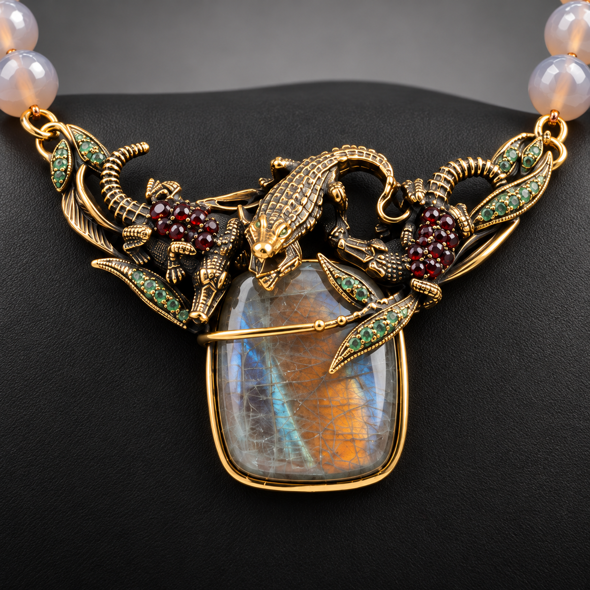 Dettaglio dell'elemento centrale con coccodrilli in ottone dorato, labradorite, smeraldi e granato