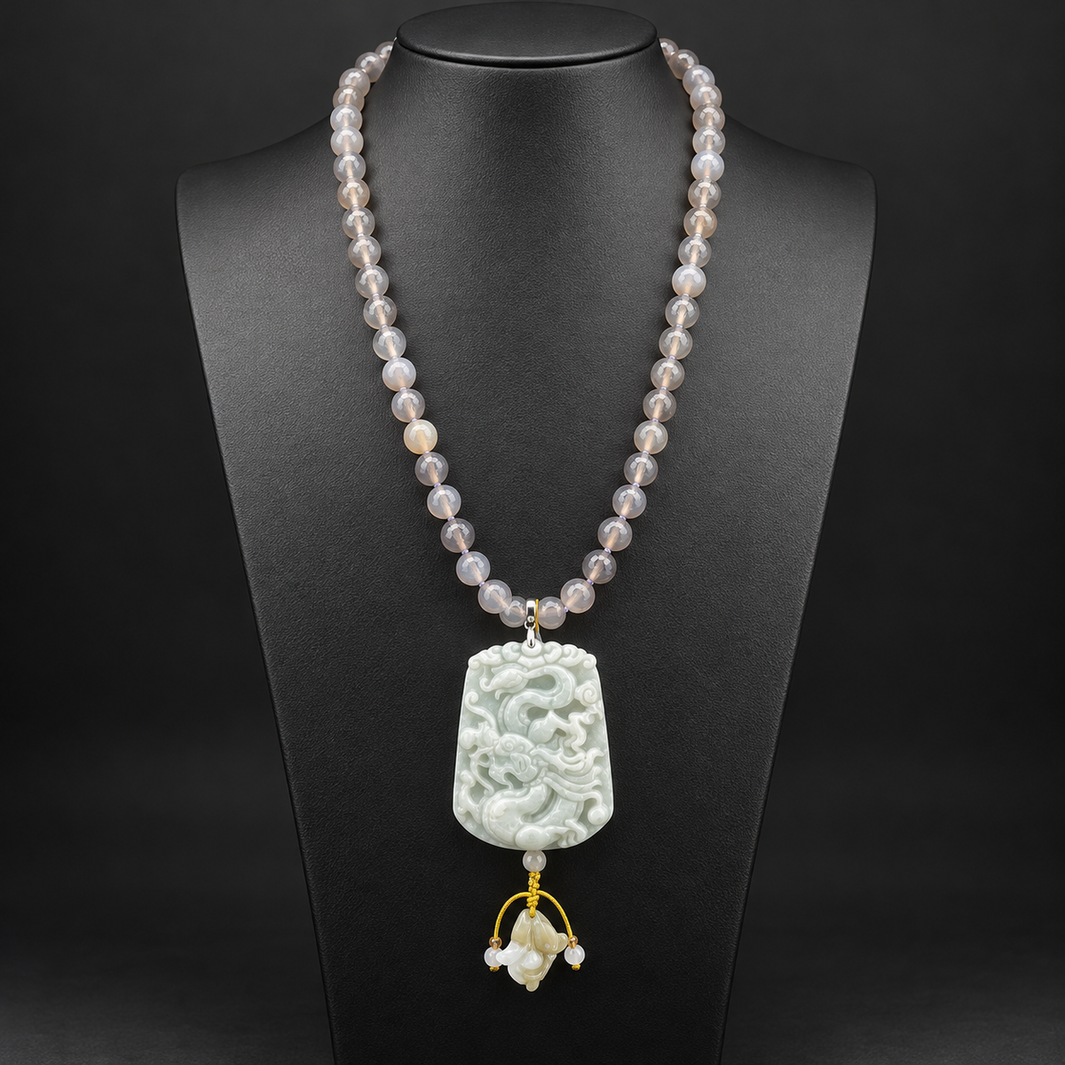 Collana lunga in agata grigia sfaccettata con pendente in giada intagliata a drago, vista frontale su busto nero