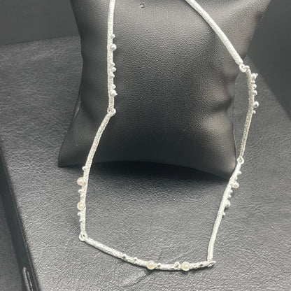 Collana argentata con piccole perle e lavorazione materica, dettaglio 2