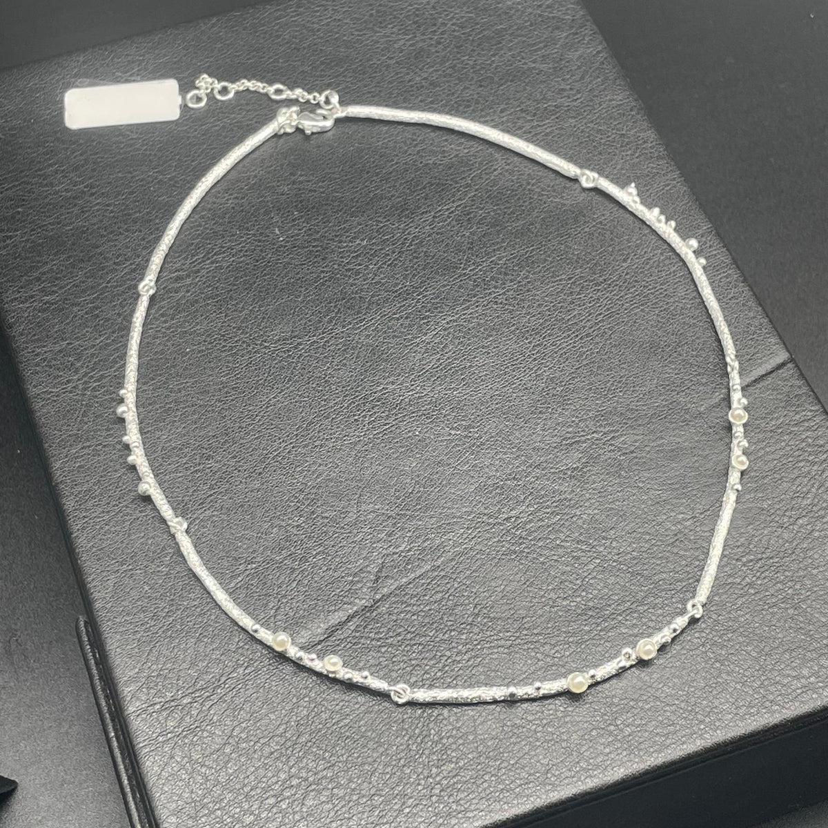 Collana argentata con piccole perle e lavorazione materica, dettaglio 3