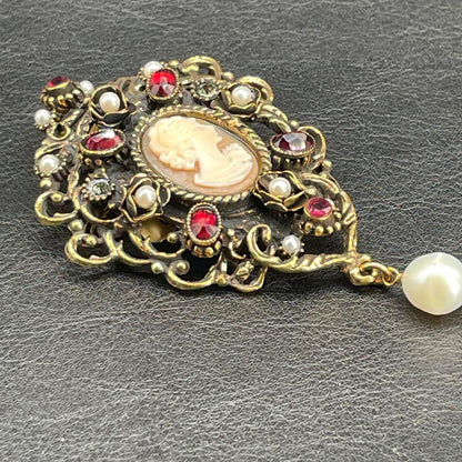 Dettaglio del cammeo centrale e delle decorazioni in ottone dorato con granati, perle e Swarovski della spilla Alcozer