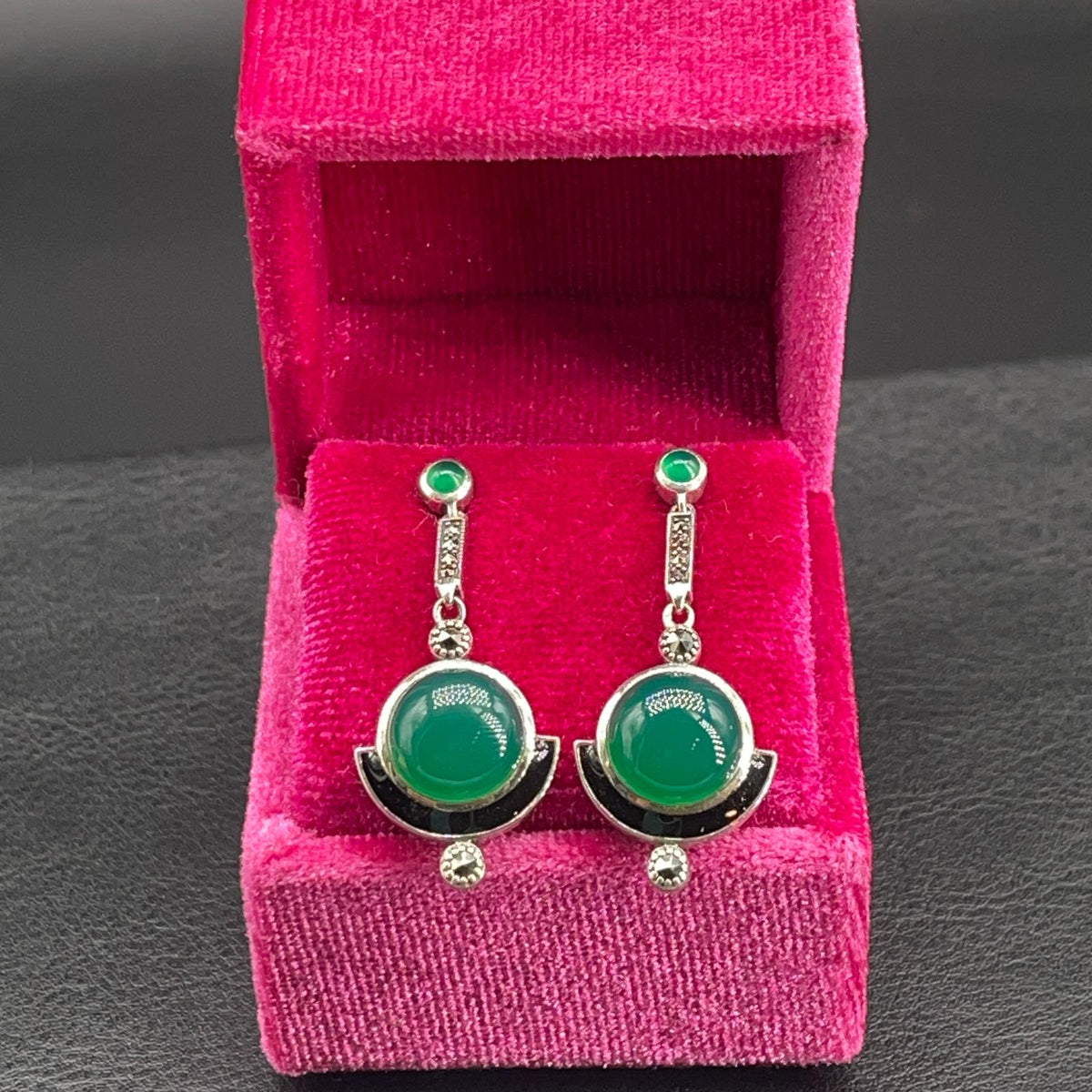 Orecchini in agata verde e marcassiti esposti nella scatola in velluto fucsia